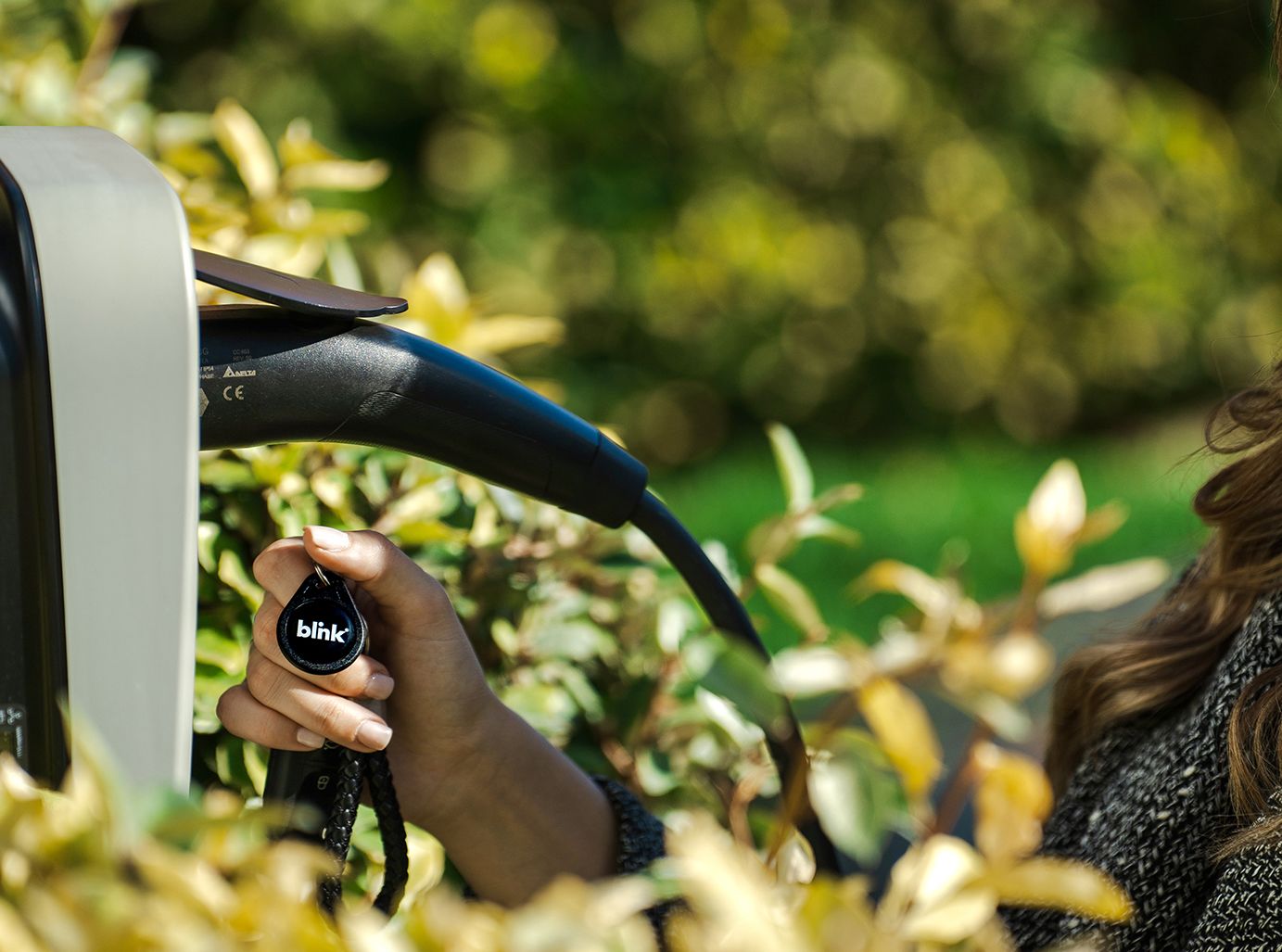 a woman standing next to a blue car